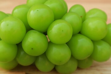 Fresh Shine Muscat or Vitis grapes close up, isolated on wooden backgroun