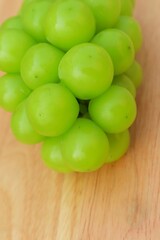 Fresh Shine Muscat or Vitis grapes close up, isolated on wooden backgroun