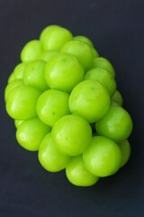 Fresh Shine Muscat or Vitis grapes close up, isolated on dark background.