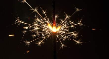Obraz premium Sparkling Celebration: Close-up of a Burning Sparklers with Bright Trails of Light Against a Black Background