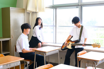 文化祭に向けてバンド練習をする生徒たち　学校の教室での青春イメージ