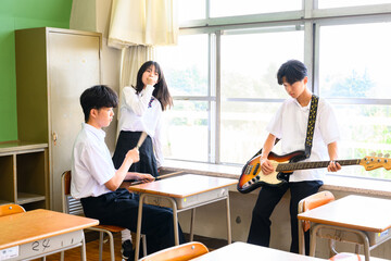 文化祭に向けてバンド練習をする生徒たち　学校の教室での青春イメージ