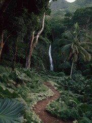 Obraz premium Beautiful waterfall cascading down a rocky cliff in the middle of a lush green forest. the waterfall is surrounded by tall trees and palm trees, and the ground is covered in greenery.
