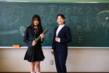 小学校の教室で担任の先生と卒業式を迎えた女の子　教育・学び・感動のシーン