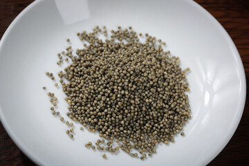 Highland Black Millet Grains on White Plate - Organic Superfood Cereal Seeds for Healthy Cooking and Porridge