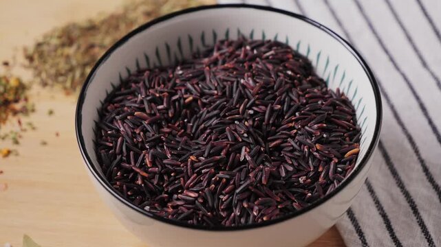 Organic raw red rice in a bowl. Healthy nutrition concept. High quality 4k footage