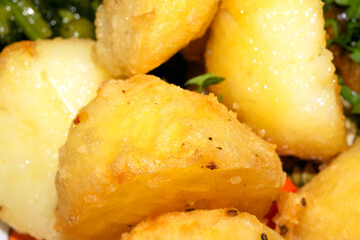 Close up of delicious fresh roast potatoes cooking in fat oil close up