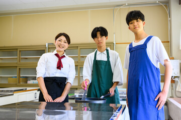 料理教室で学ぶ男子学生と女性講師　料理レッスン風景