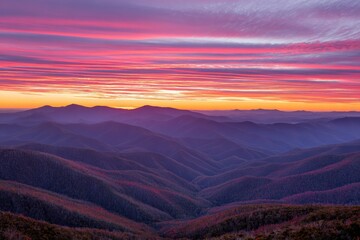 Vibrant sunset hues paint rolling hills and distant mountains