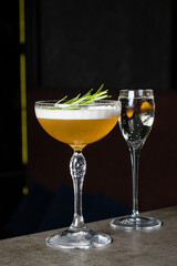 Two beautifully crafted cocktails sit atop a bar counter, capturing the essence of a lively night