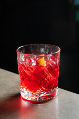 A vibrant cherry cocktail invites exploration on a polished surface in soft lighting