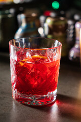 Brightly colored cocktail rests on a bar counter, enhanced by citrus and a relaxed atmosphere