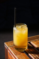 A chilled drink with ice cubes sitting on a rustic wooden table, inviting and refreshing