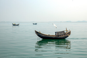 Naklejka premium Traditional Wooden Boats Sailing on Calm Lake Under Clear Sky