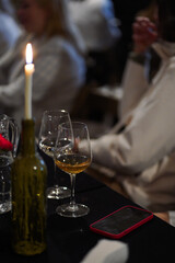 Candlelit table with wine glasses and smartphone during an evening social event