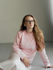 Young blondie attractive woman in eye glasses siting in studio. Business smart woman concept