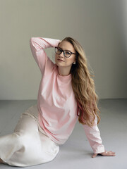 Young blondie attractive woman in eye glasses siting in studio. Business smart woman concept