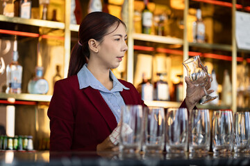 Asia woman cleaning a glass at bar	