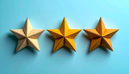 Three golden origami stars on a light blue background, artistic composition.