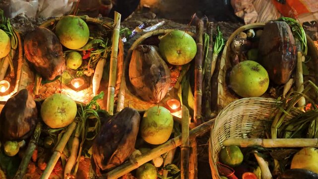 hindu chhath puja daali filled with fruits and lit diya at sacred riverbank