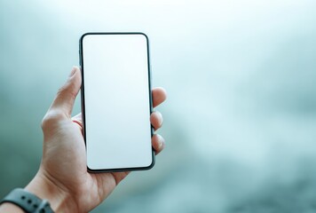 Hand holding a blank-screen smartphone against a soft, blurred background of blue and white tones. Minimalist, focused on device and human interaction