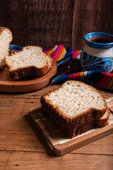 Salvadoran yolk bread, accompanied by a cup of hot chocolate.