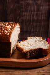 Salvadoran yolk bread with sesame seeds, on a wooden tray