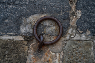 Old, rusty mooring rings on the stone quay.