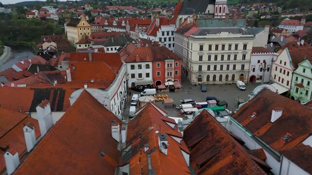 Low Aerial Drone Pan Around Historic Central Square (N&aacute;měst&iacute; Svornosti) in Cesky Krumlov, Czechia, Showcasing Old Town Architecture on an Overcast Day.
