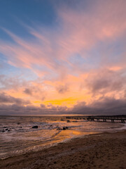 Sunset sky reflecting in the Baltic sea, view from the sandy shore in Sweden.