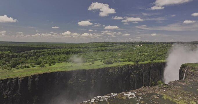 Victoria Falls Zimbabwe Aerial v3 flyover capturing immense chasm and powerful mist rising from the cascading Zambezi River amidst lush green landscapes - Shot with Mavic 3 Pro Cine - Jan 3rd 2024