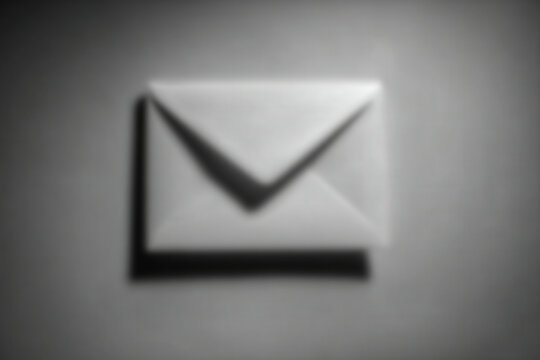 blurred white text bar enveloping mailing envelope with ar address set against monochrome wall