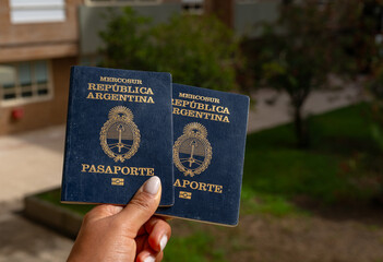 Pasaportes argentinos sostenidos en la mano, documentos de viaje MERCOSUR