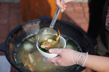 Serving a Variety of Delicious Soups from a Big Pot to Delight Everyones Palate