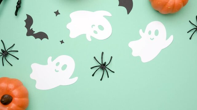 Cute white ghosts bats and spiders on pale green background for Halloween celebration