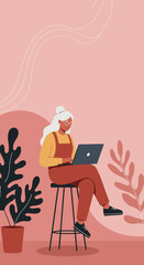 An engaged senior woman with glasses uses a laptop while sitting on a stool, representing digital literacy, remote work, or online learning for older generations.