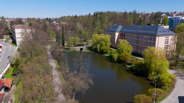 Glide through the lush trees and over the tranquil pond of Park Budoucnost, a beautiful public green space in Havlickuv Brod, Vysocina, Czechia.