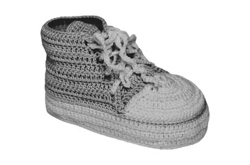 Black-and-white halftone image of crocheted baby shoes with laces, resembling tiny sneakers
