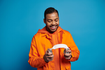 Joyful moments of a young man in vibrant orange attire against a bright blue backdrop