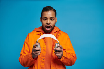 Vibrant young man expresses excitement in casual autumn attire during a studio shoot