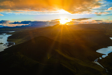Aerial view of Iceland's rugged terrain featuring volcanic craters, a winding river, a serene lake,...