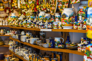 Naklejka premium Typical souvenirs in a shop in historic village San Gimignano, Tuscany, Italy. Detail of a local shop in the streets. Traditional souvenirs of ceramics. Europe tourism or vacation travel concept.