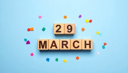 Wooden Blocks with Date 29 March. Calendar for birthday or anniversary on solid colored background with confetti