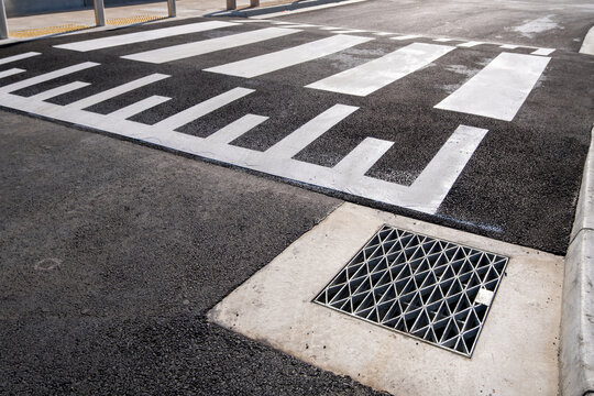Raised pedestrian crosswalk on an asphalt road with stormwater drain. Designed for safer crossing and traffic calming in Australia. Concept of road safety, public infrastructure