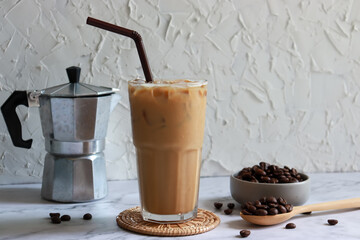 Iced coffee glass with moka pot and roasted coffee bean