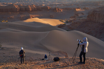 Landscape Photographers Capturing Dunes at Golden Hour in Desert Landscape