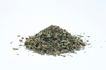 pile of dried and chopped basil spice on white background