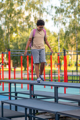 Boy at the playground walking and keeping balance