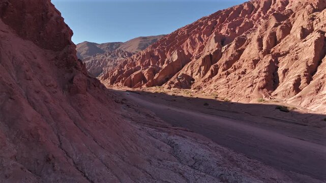 Aerial view of the majestic Valle del Arcoiris, with its vibrant red rock formations contrasting against the vast desert landscape, Valle del Arcoiris, San Pedro de Atacama, Chile.