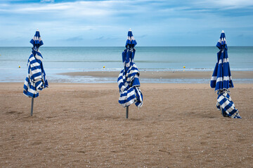 3 parasols rayés bleu et blanc alignés